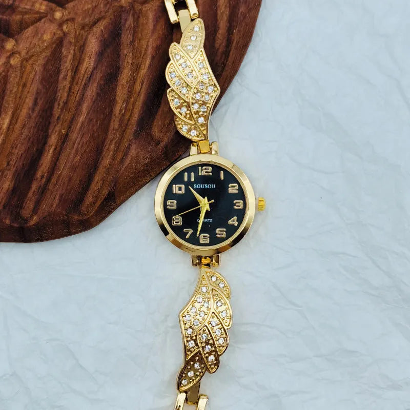 Round stainless steel women's watch on wrist showing gold surface colour and vachette clasp buckle.