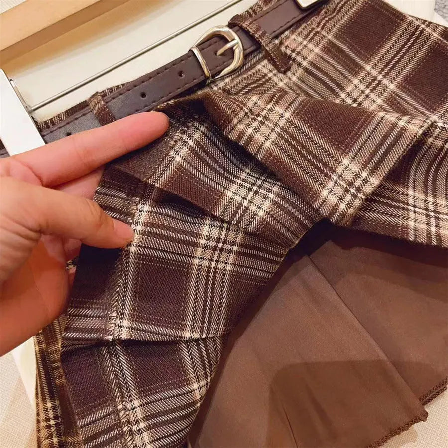 Girls' plaid pleated A-line skirt in cotton blend fabric on a hanger.