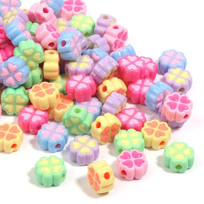 Assorted frosted acrylic four-leaf clover shaped beads in pink, green, and yellow, 15mm diameter.