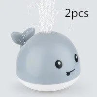 Automatic water-spraying whale bath toy with colourful lights floating in bath water.