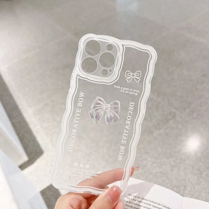 Transparent TPU iPhone case with 3D ice-through bow design on a mobile phone, showing optional white love lanyard attached.