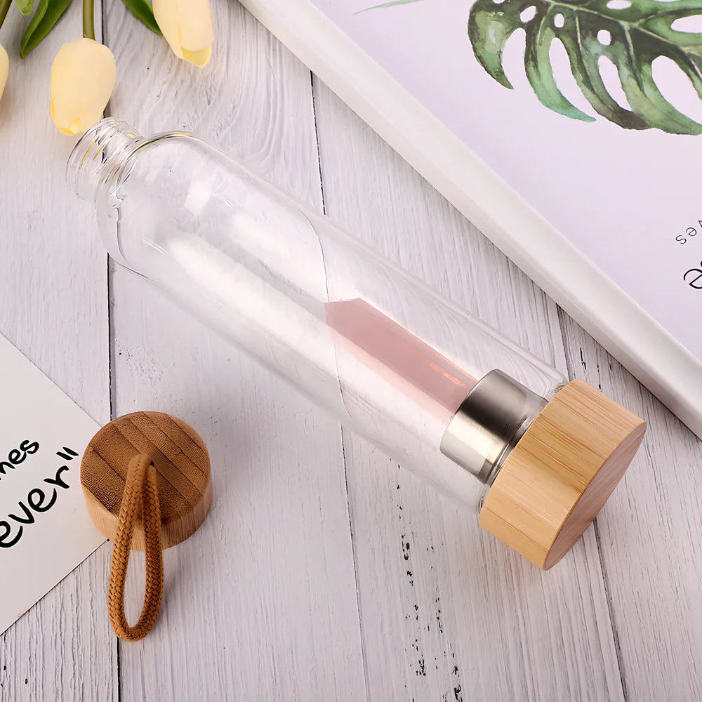 Crystal infused glass water bottle with bamboo lid showing mineral crystal inside 25cm tall container