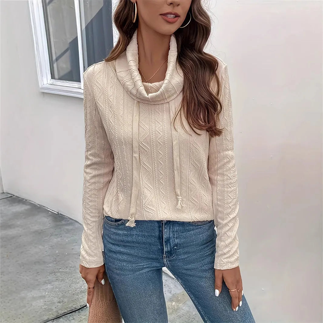 Apricot coloured long sleeve hooded pullover sweater with drawstring on a hanger