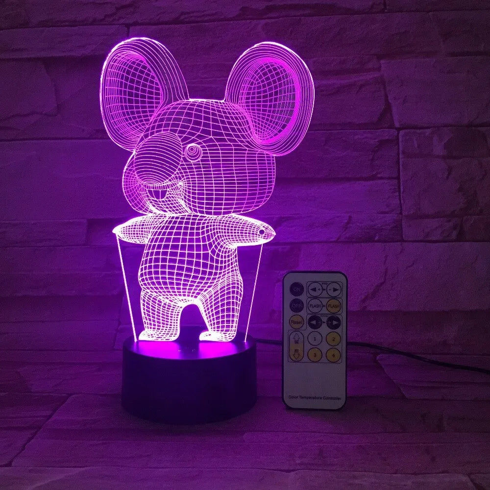 Black Koala night light with LED illumination on a bedside table.