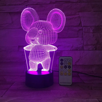 Black Koala night light with LED illumination on a bedside table.