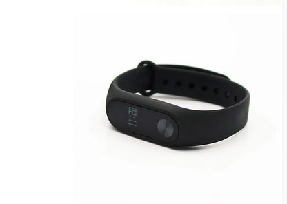 Xiaomi Mi Band 2 black fitness tracker with OLED display showing heart rate and time on adjustable wrist strap