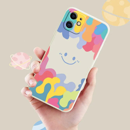 White silicone iPhone case with rainbow smiley face pattern and attached lanyard