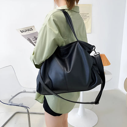 Large soft black PU messenger bag with long shoulder strap and front car suture detailing