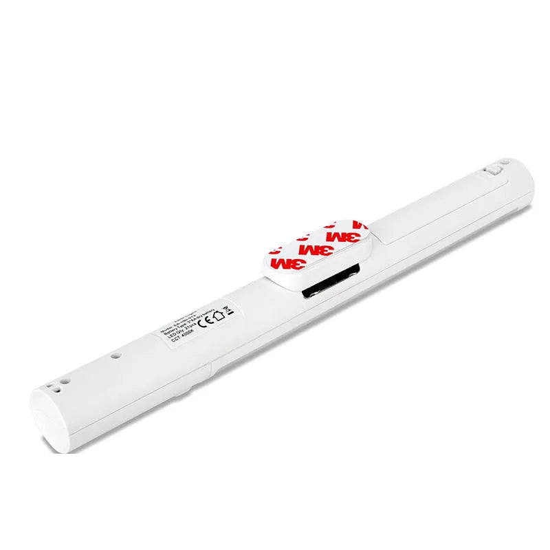 Slender white human body induction LED cabinet light with magnetic back for tool-free installation.