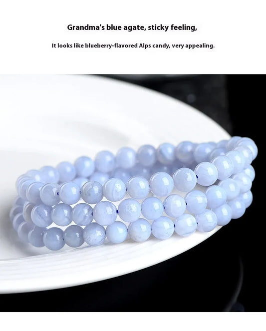 Blue agate bracelet with 6-6.8mm beads in multi-circle pattern and Ruyi elements on a wrist.