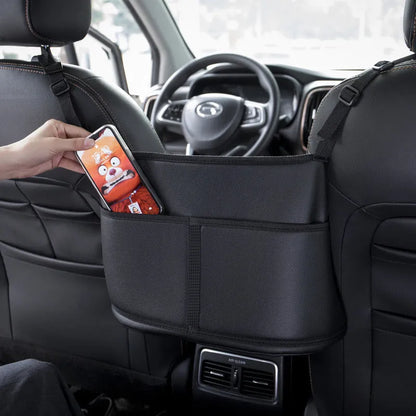 Black leather car seat gap storage bag with carbon fibre pattern, shown between car seats.