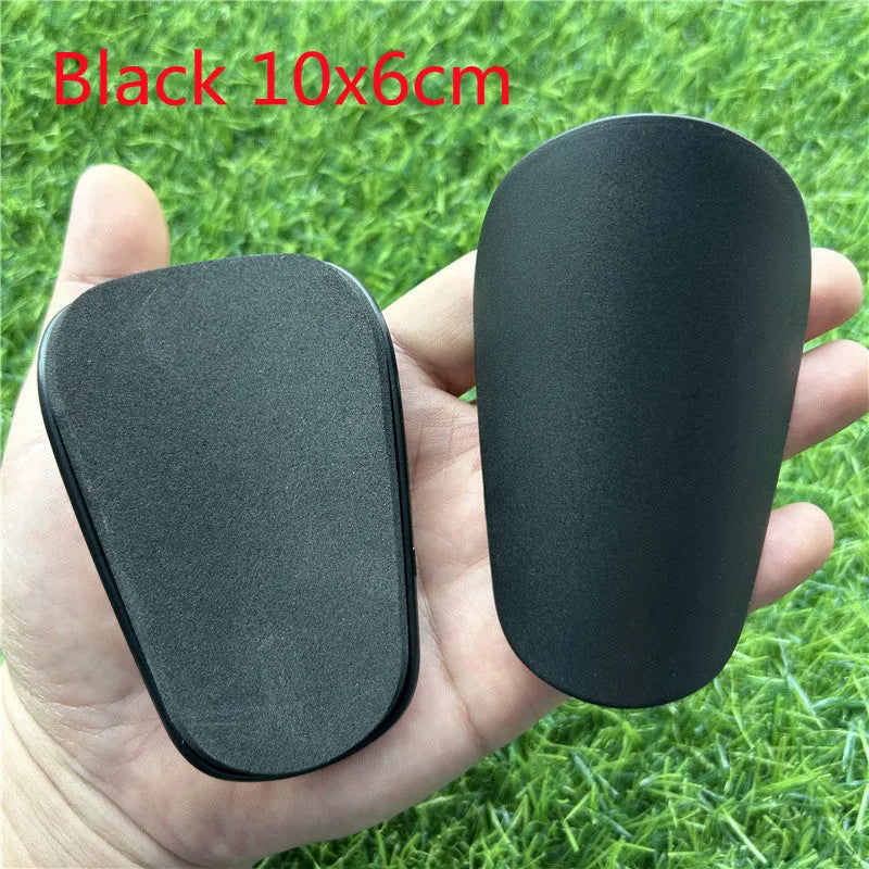 Extra small plastic football shin guards in black and white colours for youth players