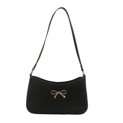Western style shoulder bag with bow detail in rose pink colour, showing horizontal square shape and single strap.