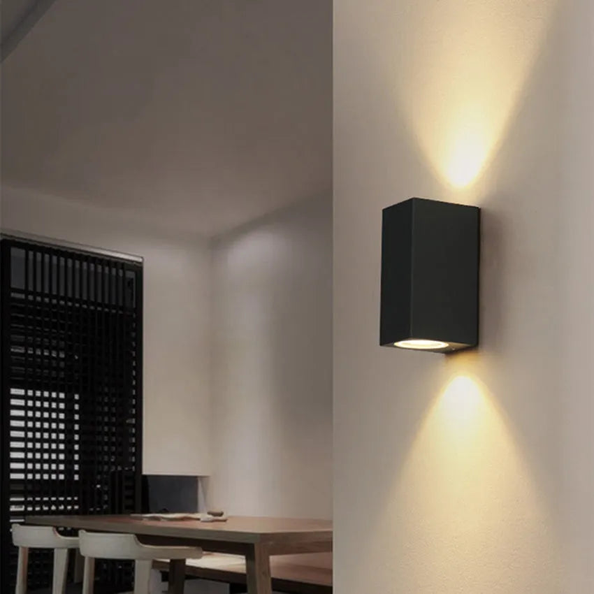 Black LED wall lamp with aluminium body and glass shade mounted on wall