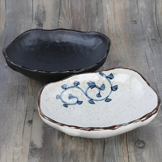 Japanese style irregular shaped ceramic sashimi bowl with floral decoration on table.