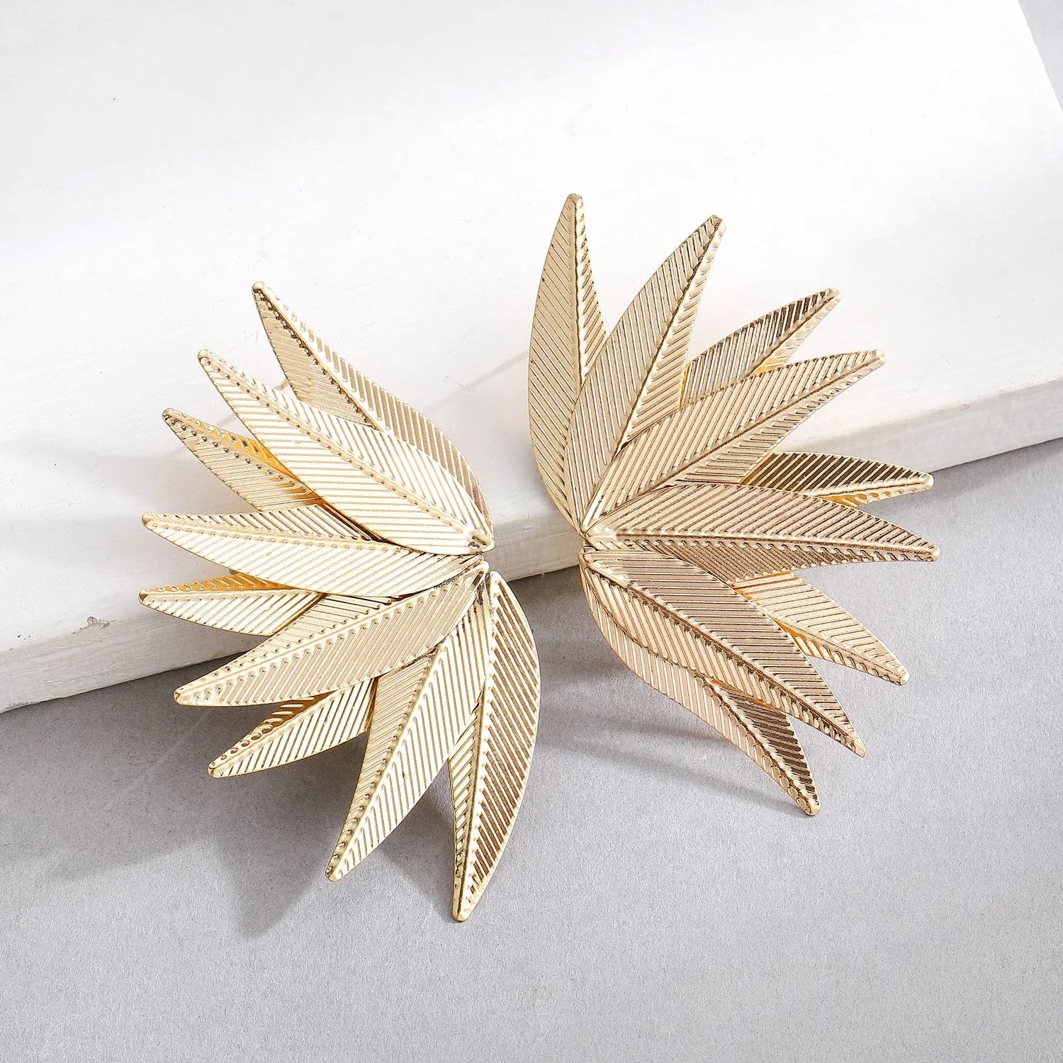 Gold and white alloy leaf-shaped patch earrings with dangle design