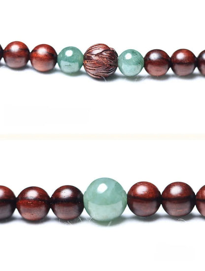 Rosewood bead bracelet with a carved wooden 108 bead and a green Hotian jade pendant on a neutral background.