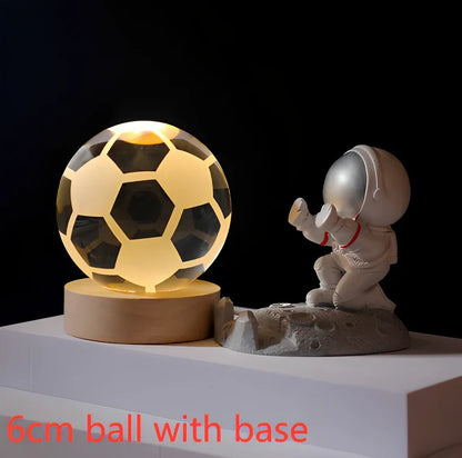 3D crystal ball night light projecting solar system pattern on wooden base with astronaut figurine