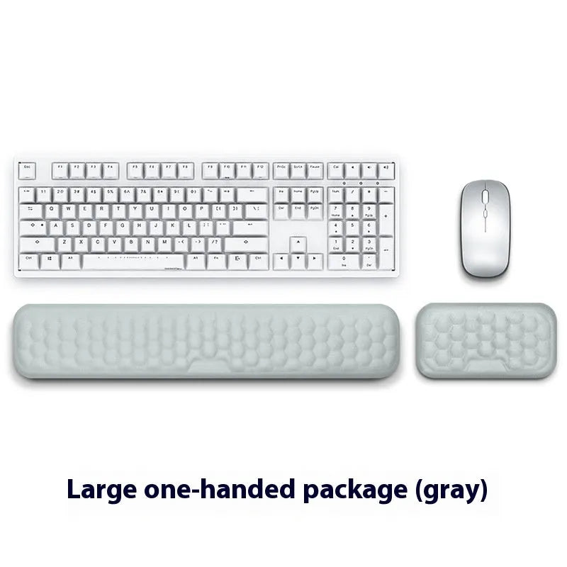 Black and grey memory foam mouse wrist rests with cloth and leather-style covers on a desk.
