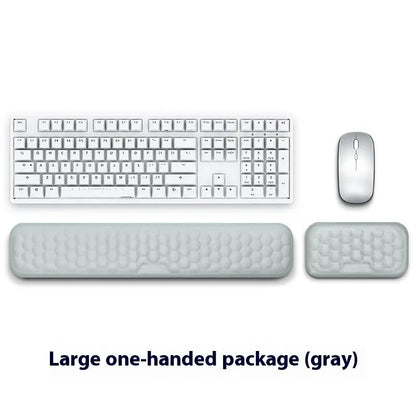 Black and grey memory foam mouse wrist rests with cloth and leather-style covers on a desk.