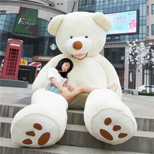 A giant, plush teddy bear in a variety of sizes and colors, including light brown, dark brown, gray, white, pink, and purple.