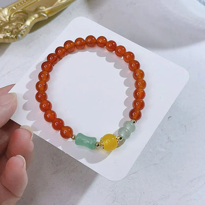 Close-up of a red agate bracelet featuring a detailed dragon design in a Chinese style.