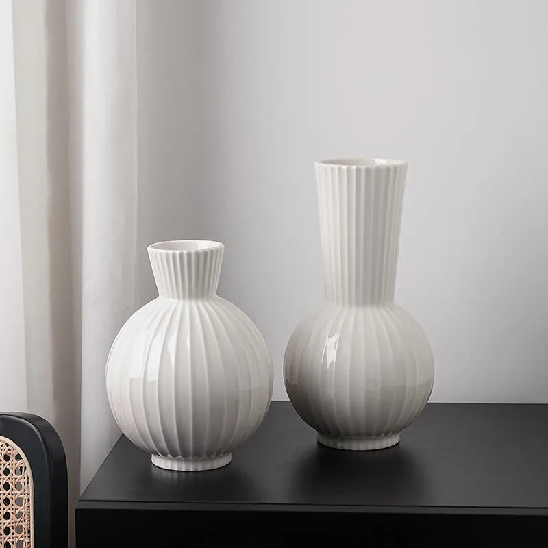 White ceramic ball-shaped vase with striped pattern, shown in small and large sizes with orchid arrangements