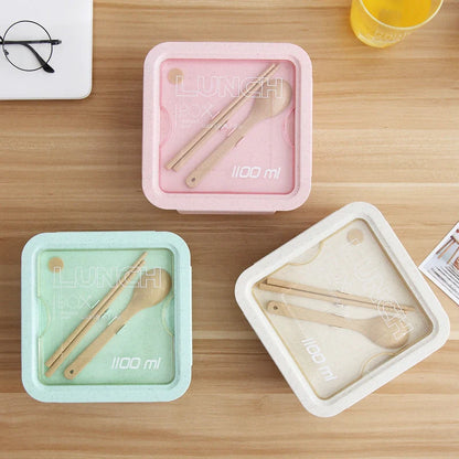 Japanese-style microwave-separated bento box in pink, green, and beige with spoon and chopsticks