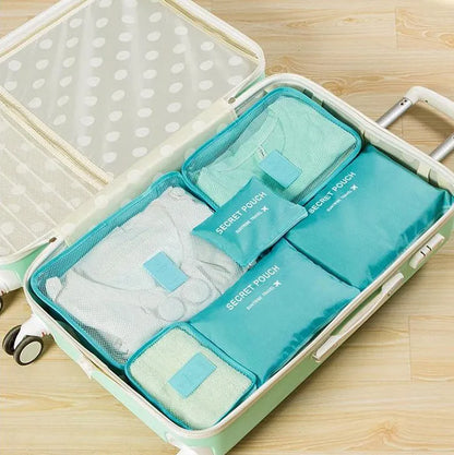 Set of six coloured nylon packing cubes and flat pouches for travel organisation.