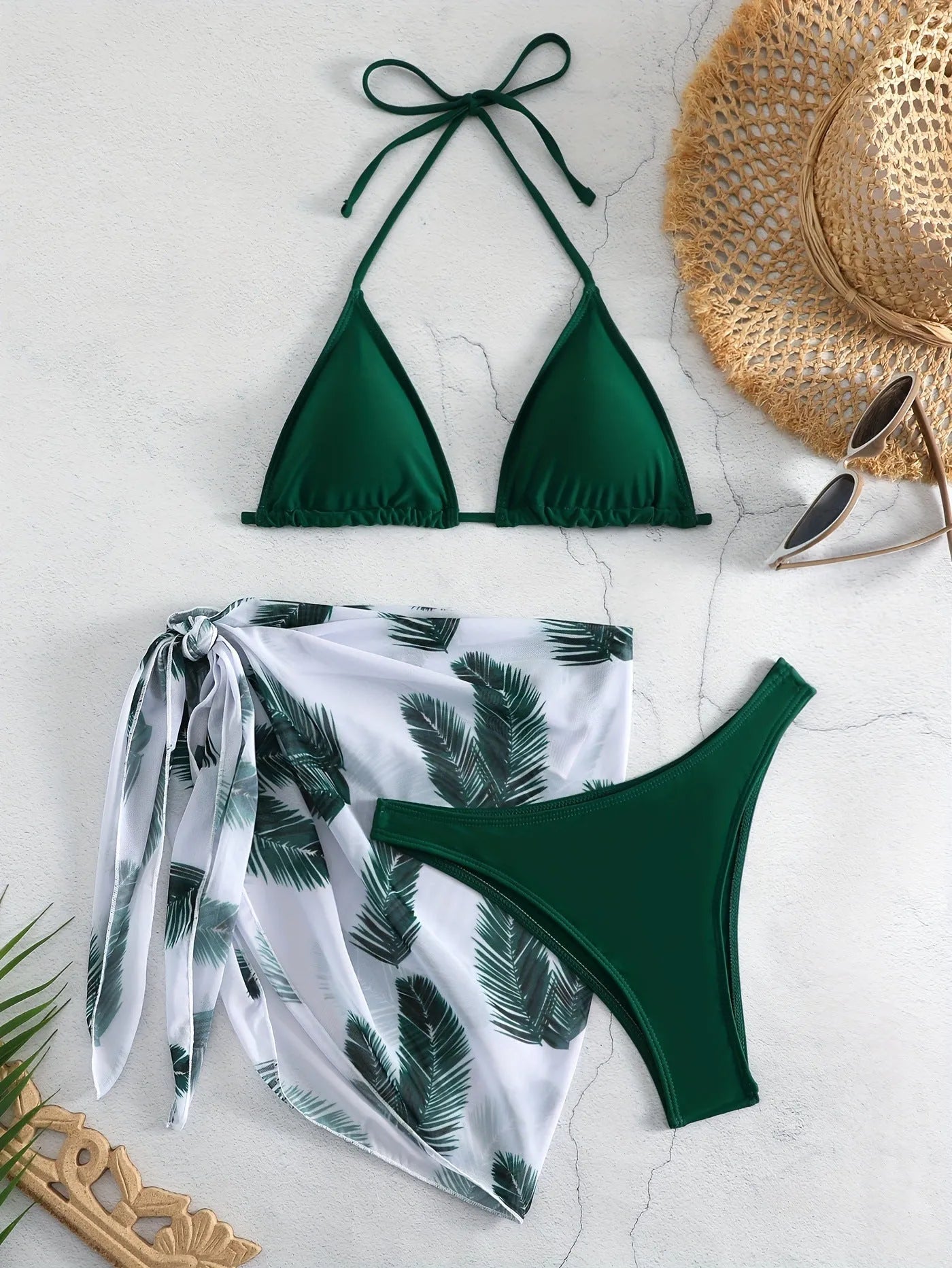 Women's orange three-piece bikini swimsuit with a matching printed gauze skirt laid flat.