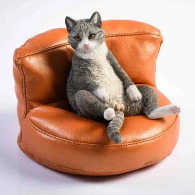 Lazy cat ornament on miniature sofa for car dashboard decoration, 7.5cm high with fabric art detailing