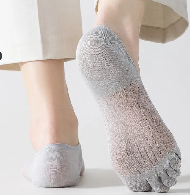 Pair of solid colour modal five-finger boat socks laid flat, showing individual toe compartments and low-cut design.