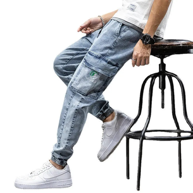 Men's blue cargo jeans with straight-leg fit, micro-elasticity fabric, and cargo pockets on a hanger.
