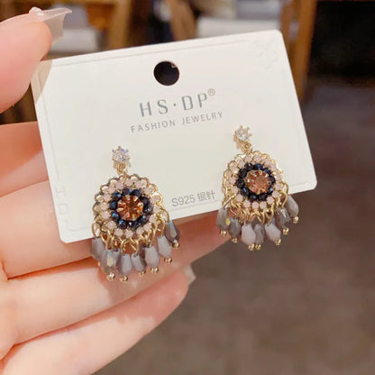 Gold plated geometric earrings with blue diamond-embedded crystals in tassel design