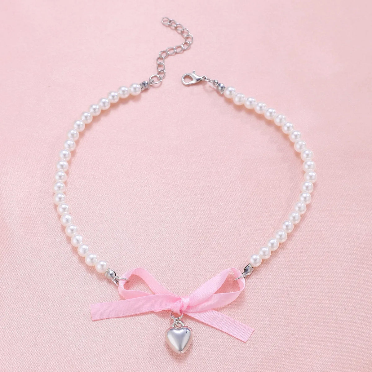 Love heart and bow tie clavicle chain necklace with pearl inlay, shown in White K Love 028 and White K Bow 026 options.