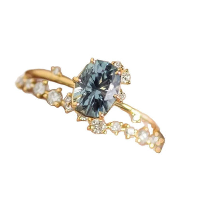 Gold-plated floral women's ring with a central green zircon stone on a model's hand.