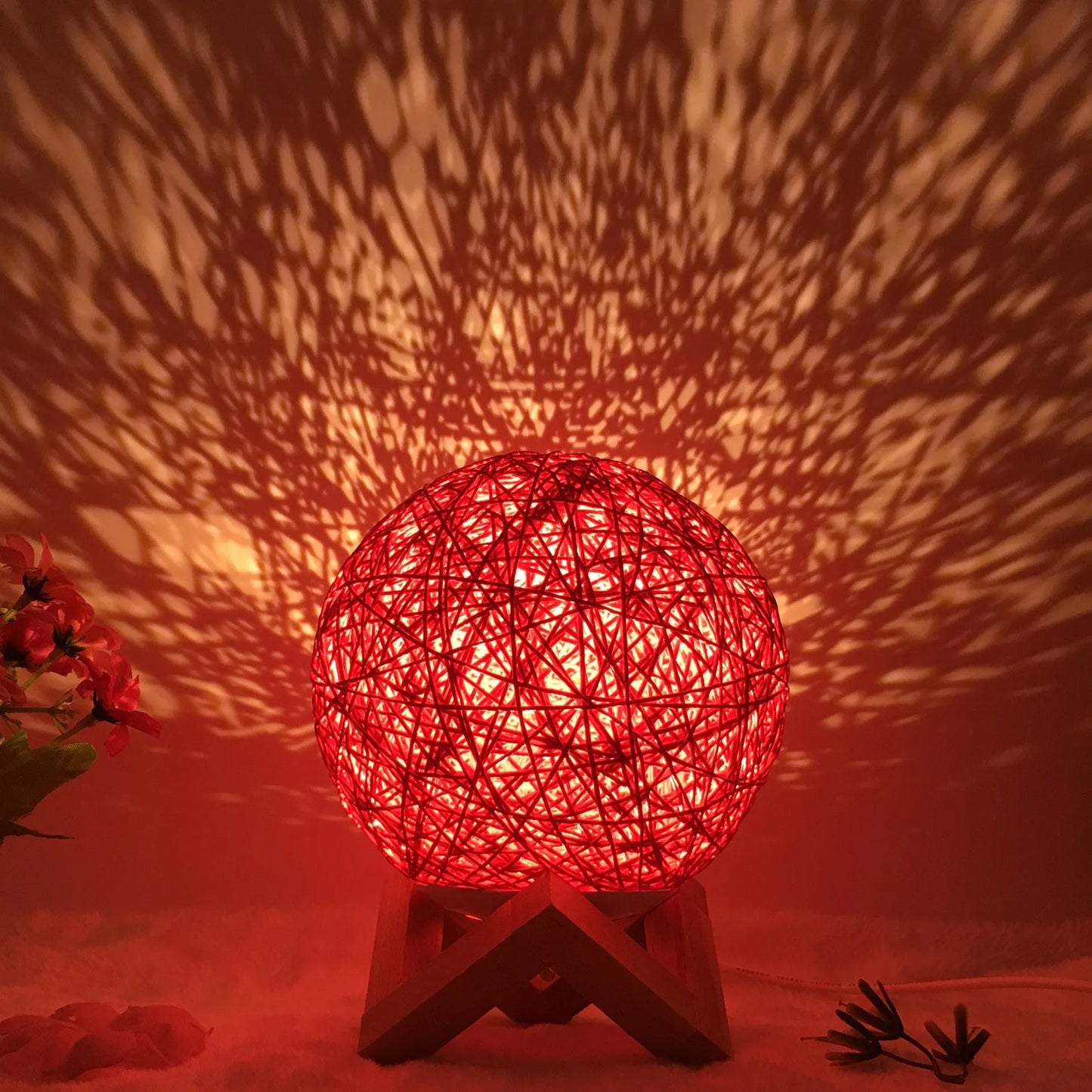 Spherical hand-knitted rattan table lamp with remote control on a wooden desk