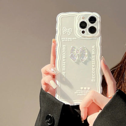 Transparent TPU iPhone case with 3D ice-through bow design on a mobile phone, showing optional white love lanyard attached.