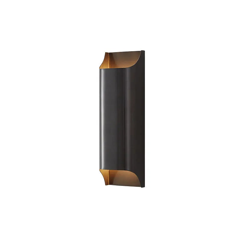 Minimalist copper wall lamp in black gold finish mounted beside bed