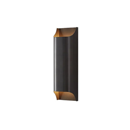 Minimalist copper wall lamp in black gold finish mounted beside bed