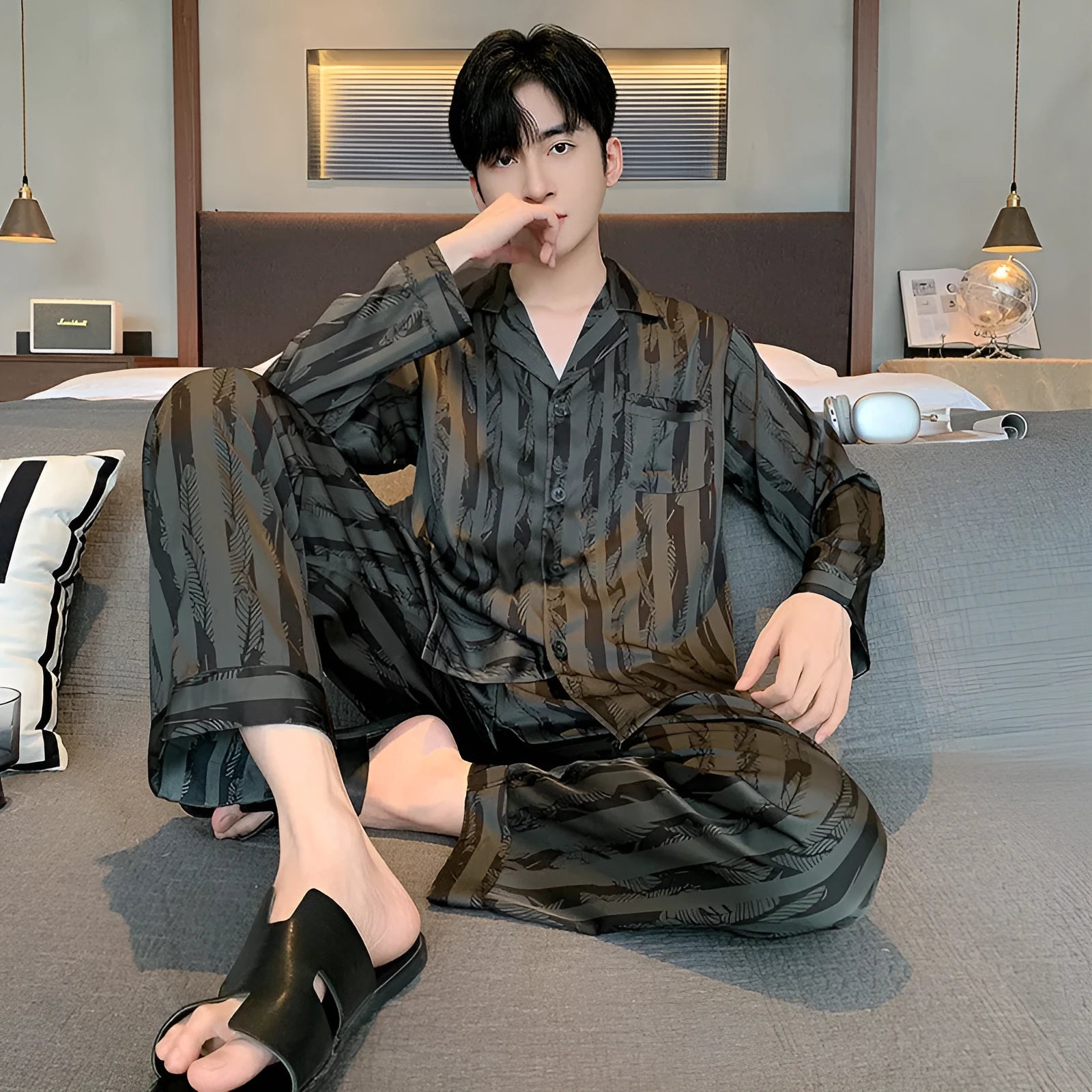 Black stripes men's ice silk pyjama set with V-neck top and long trousers on a hanger.