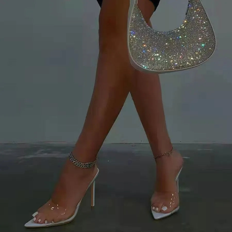 Women's black ultra-high vamp stiletto heel slippers with a pointed toe on a plain background.