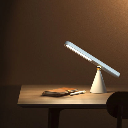 A modern, geometric desk lamp with wireless charging and a magnetic suction base for easy placement
