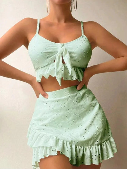 Women's white split hip skirt three-piece bikini swimsuit set on a mannequin.