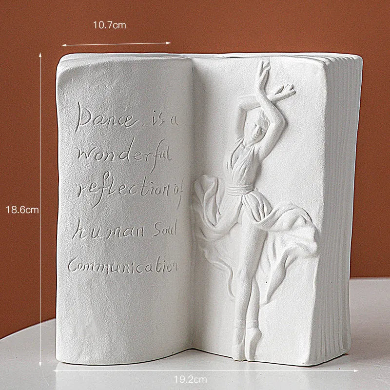 White ceramic book stand holding an open book at an angle, with a wire page holder in use.