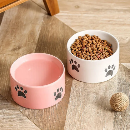 Ceramic cat bowl with high foot and cat's paw base in an oblique mouth design.