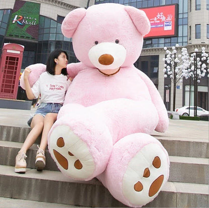 A giant, plush teddy bear in a variety of sizes and colors, including light brown, dark brown, gray, white, pink, and purple.