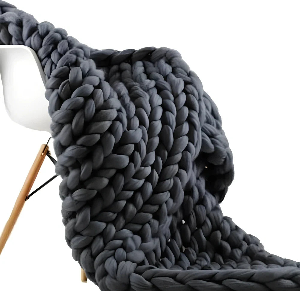 Hand woven wool blanket with soft chenille texture in navy blue colour draped over sofa