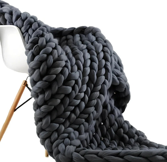 Hand woven wool blanket with soft chenille texture in navy blue colour draped over sofa