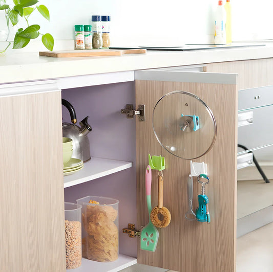 Blue plastic kitchen organiser mounted inside cabinet door holding spatula and spoon